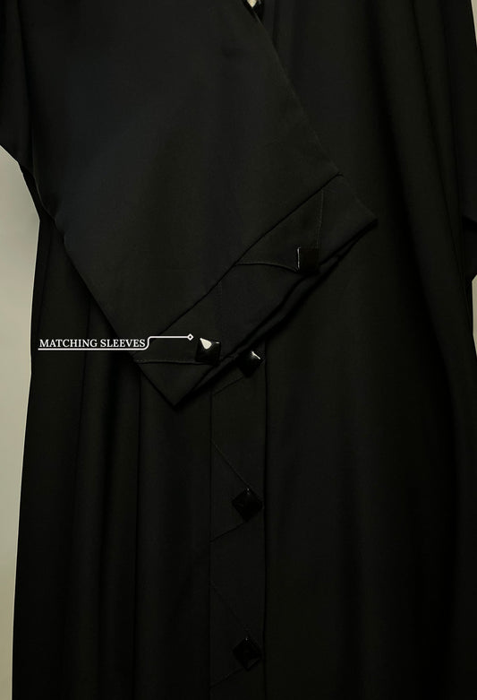 Close-up of the matching sleeve design on the Black Diamond abaya, featuring the same diamond-shaped button accents.