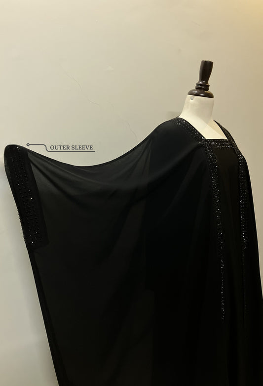Close-up of the Imperial kaftan’s dual-layer construction, showing the flowy black chiffon draped over the opaque Nida base.