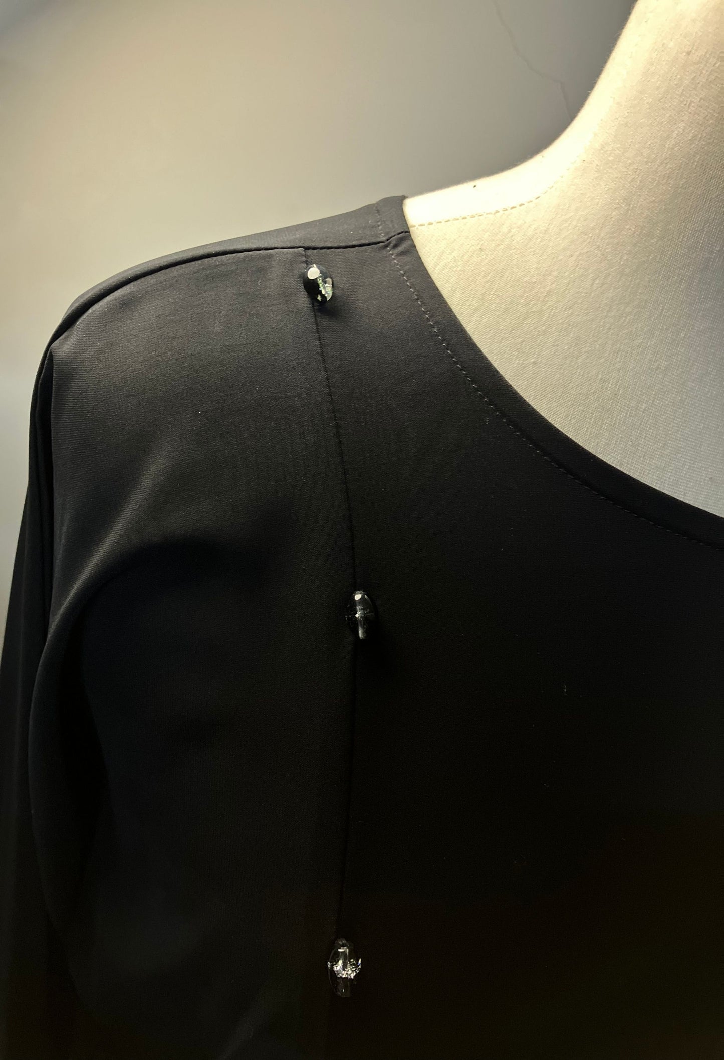 Upper body view of the Midnight abaya showing the round neckline and sophisticated button placement on Nida fabric.