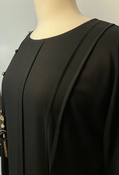 Close-up detail of the elegant front pleats and decorative black buttons on the Midnight Nida abaya – Tarha.pk Classics V2.