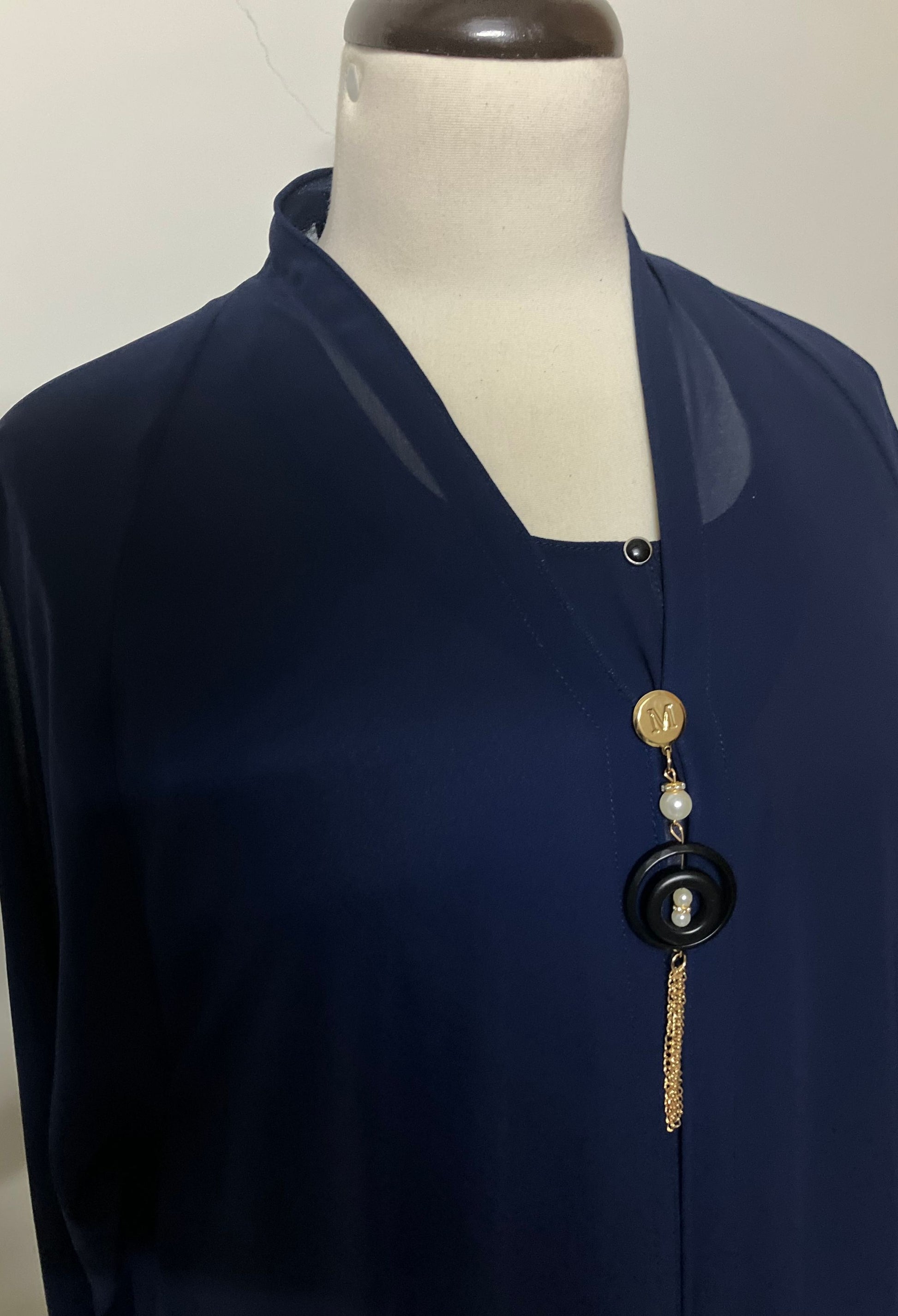 Close-up of the V-neckline and elegant beaded tassel accessory on the Sapphire blue chiffon kaftan.