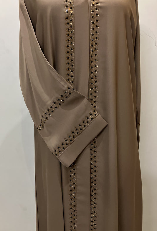 Close-up of the sophisticated golden embroidery and stitching on the sleeves of the Zahra Nida abaya.
